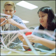 Summer campers building a bridge out of straws.