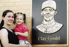 Julie and Logan Gould in front of bronze plaque with Clay Gould's likeness
