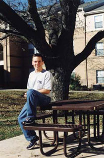 Ryan Garrett sitting outside Arbor Oaks Apartments.