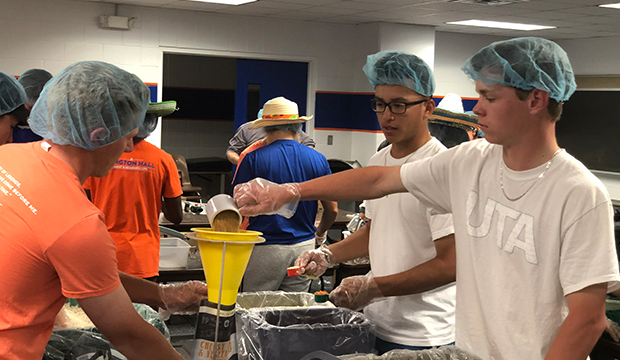 UTA student athletes assist in a kitchen as part of community service.