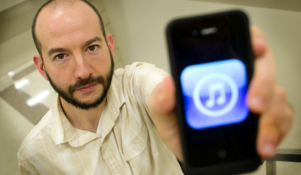 Music professor David Arditi holds a cellphone with musical notes on its screen