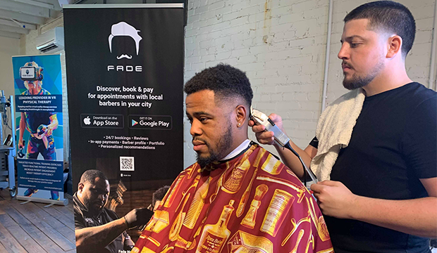 Startup business Fade employee gives a haircut to a customer.