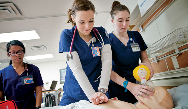 Nursing students doing CPR on a maniken