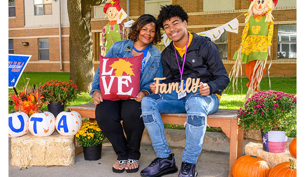 Mother and son sitting on straw bale during Parent and Family Weekend.