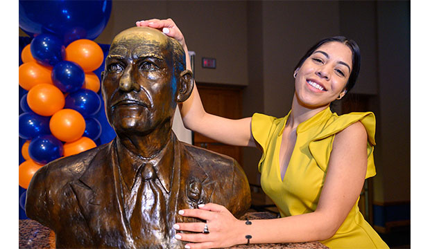 Woman rubbing head of bronze bust of E.H. Hereford at the Maverick Ring Ceremony.