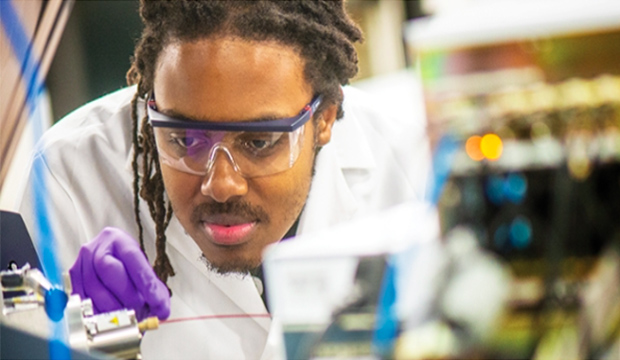 A student looking at a test tube.