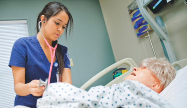 Female nursing student taking blood pressure on a simulated patient.