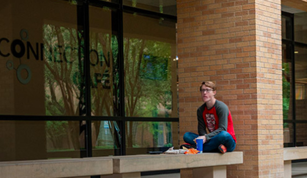 Student sitting on ledge at University Center.