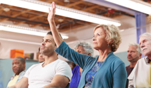 Woman in audience raising her hand.