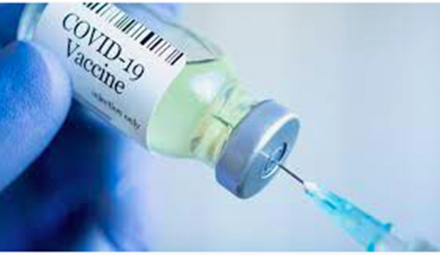 Syringe being inserted into a vial of COVID-19 vaccine.