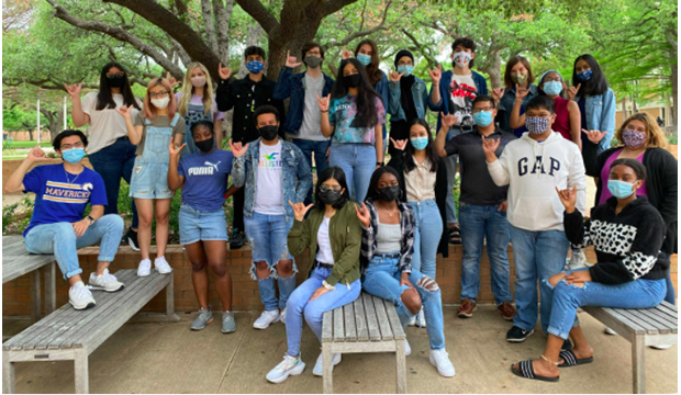 Students wearing masks sitting in a group by Central Library.