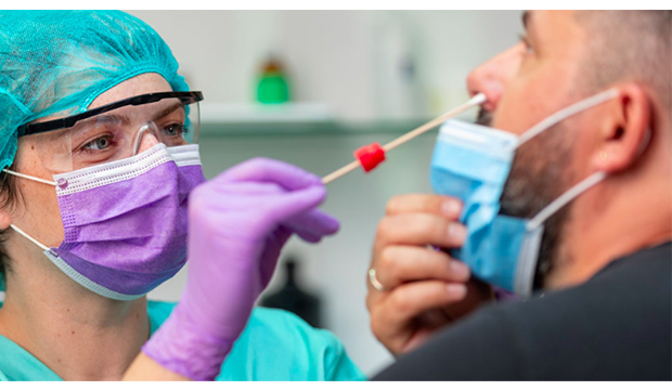Nurse giving COVID-19 test to patient.