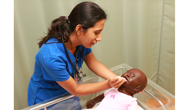 Nurse attending to pediatric manikin.