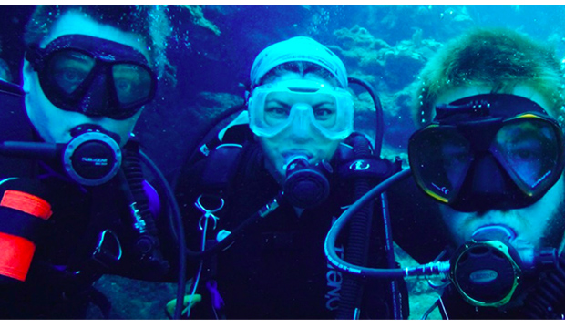 Three UTA biologists in scuba gear underwater.