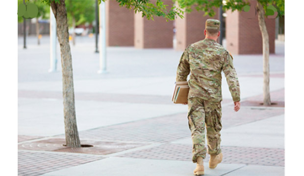 Student veteran walking across campus wearing cammo.