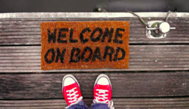 Door mat on marina dock that reads "Welcome On Board"