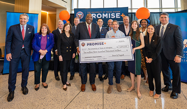 Group of people holding oversized check from the Promise Plus program to UTA.