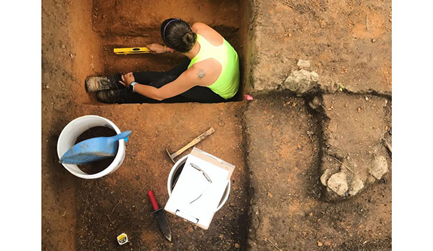 Woman working in archeology dig site.