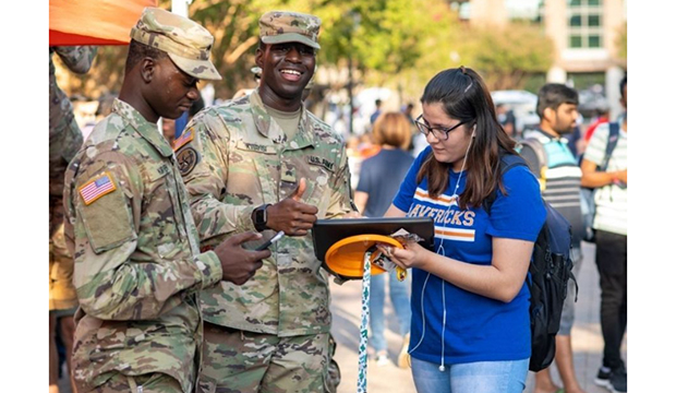 Two men in military fatigues receive some UTA swag for Veterans Day 2021.