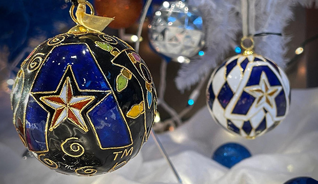 Christmas ornament ball with black background and a UTA "A" logo in blue.