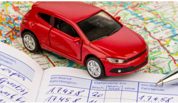 Small red car on a map and a mileage journal.