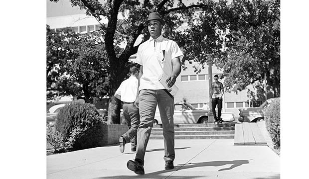 Black man walking across library mall in 1964.