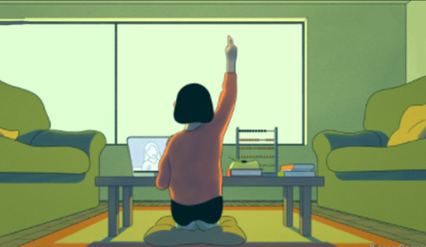 Student sitting on cushion on floor, in front of computer, raising her hand.