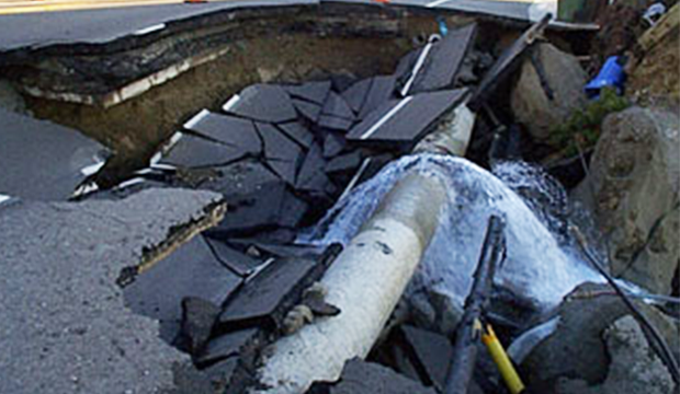 Broken water pipe under road after earthquake.