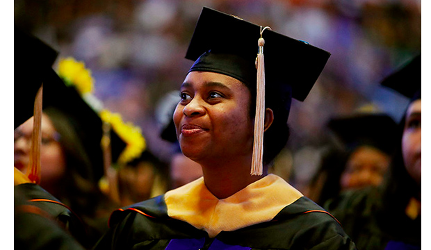 African American student at graduation, wearing a gown and mortar board.