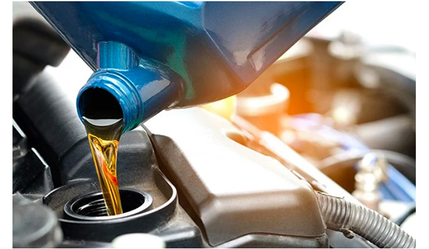 bottle pouring oil into an engine