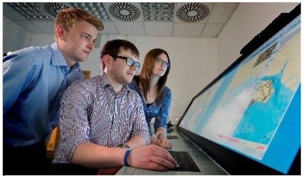 Two interns and supervisor at computer at Lockheed Martin.