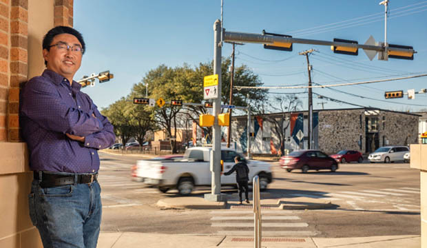 Man standing by busy town intersection.
