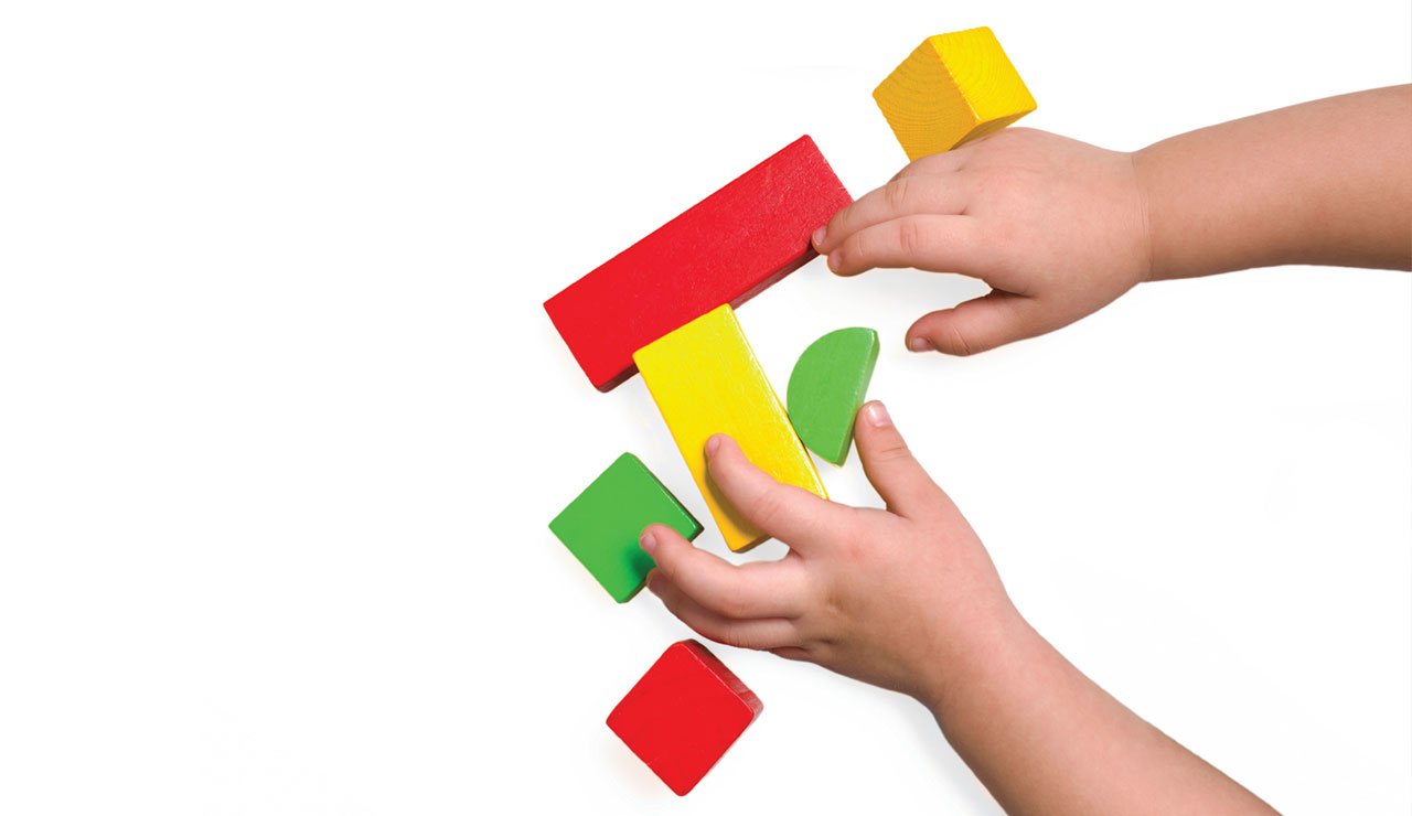 childs hands playing with blocks