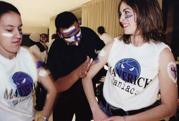 Members of the Maverick Maniacs paint themselves before a men's basketball game.