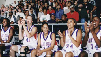The women's basketball team cheers at Midnight Madness.