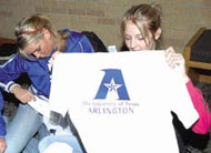 student holding up logo shirt