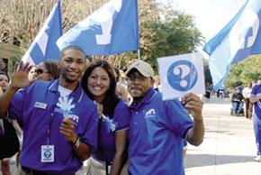 students in front of UT Arlington flags