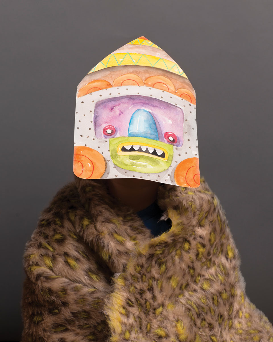 Person wearing one of a paper orange mask and leopard fur shaw