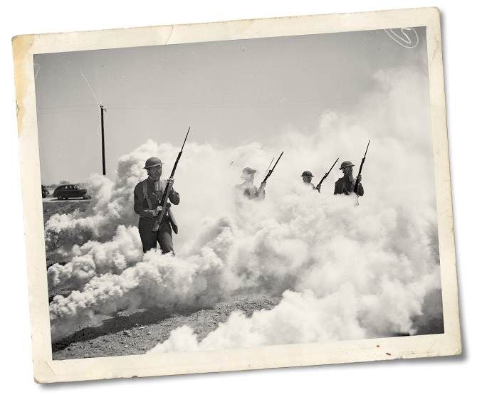 Soldiers of the 142nd Infantry walk through a simulated gas attack