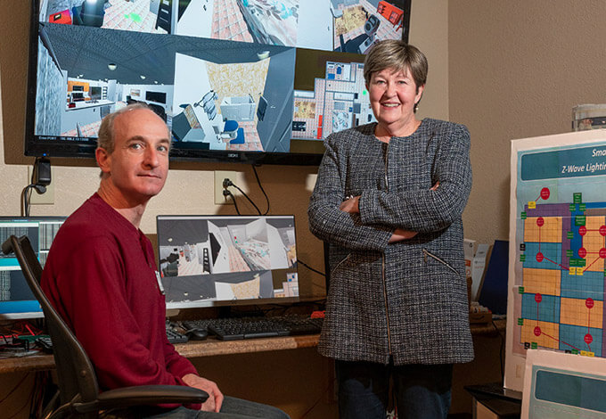 Kathryn Daniel and computer science and engineering Professor Manfred Huber in the control room of the Smart Care Apartment, a tech-enhanced living space designed to help older individuals remain healthy and independent