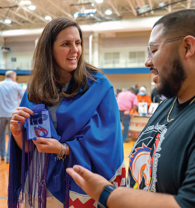 Sampson Dewey, president of UTA’s Native American Student Association (NASA), presents President Cowley with beaded earrings made by his mother at NASA’s 26th Annual Powwow.