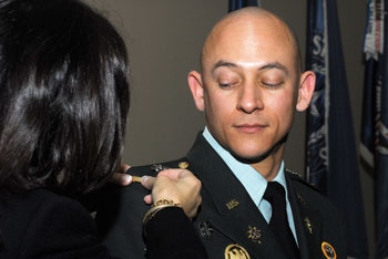 Bonnie Lugo pins a gold bar on her son, Michael Lugo