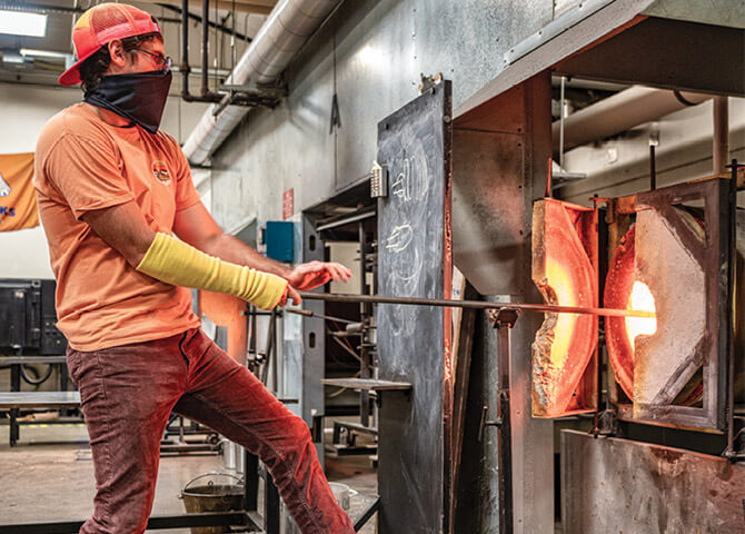 Man at kiln firing glass